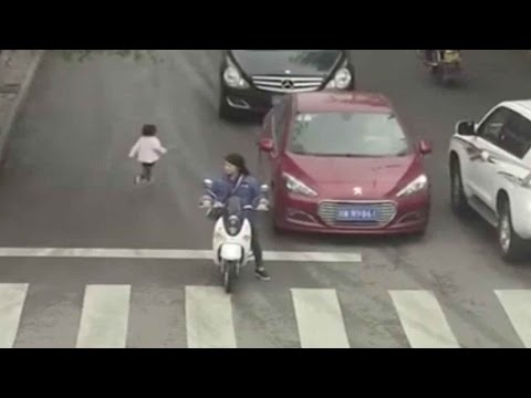 رضيعة صينية تعبر شارعًا مزدحمًا وتدهسها سيارتان ولا تتأثر