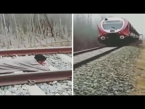 شاهد شاب يتحدى الموت مستلقيا على القضبان أثناء عبور قطار