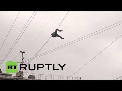 بالفيديو متهور يتعلق بأسلاك الهاتف لعبور الشارع في روسيا